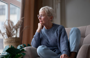 older woman resting seated on coach